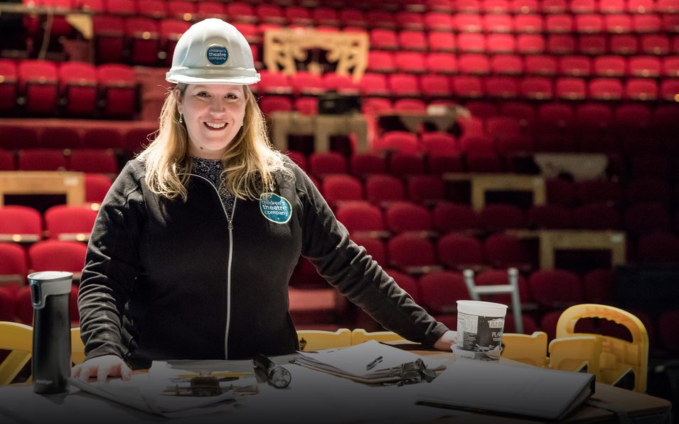 Adriane Heflin in a hard hat standing in the Children's Theatre Company theater