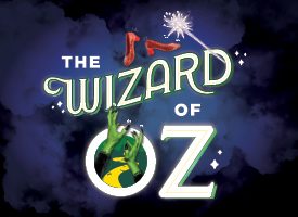 Stylized "The Wizard of Oz" text with red shoes above and inside the letter "O" green hands reaching up with a yellow brick road. Brown background.